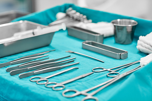 Close-up of surgical instruments. Various medical tools on blue fabric. It is in operating room.